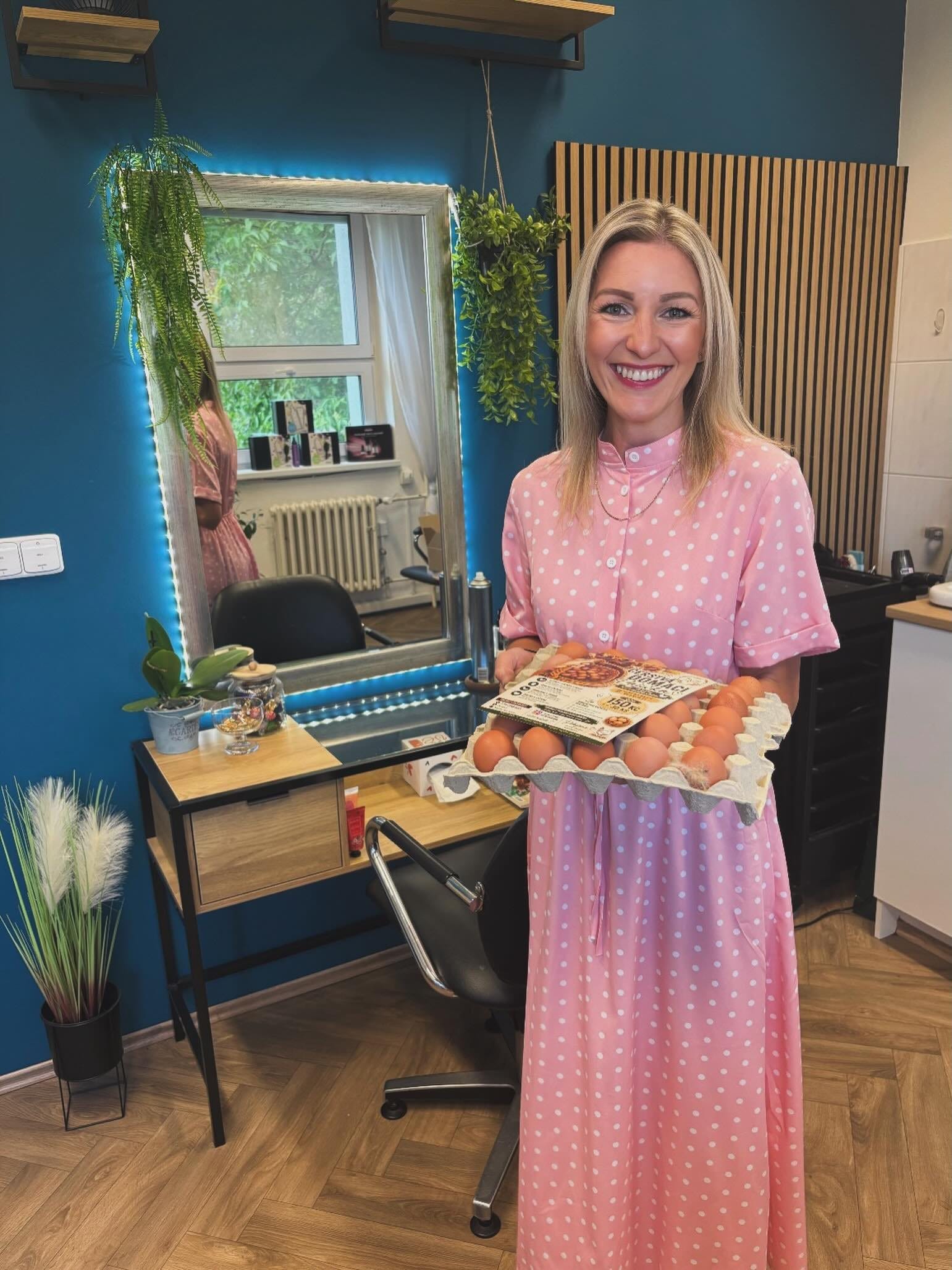 Sabina v růžových puntíkatých šatech drží plato vajec s letáčkem